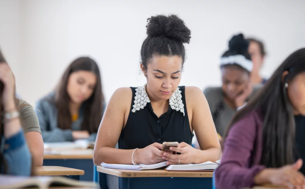 Student on mobile phone app in class