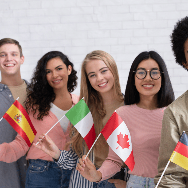Internationale Studenten, die ein Studentenvisum benötigen, halten ihre Landesflagge