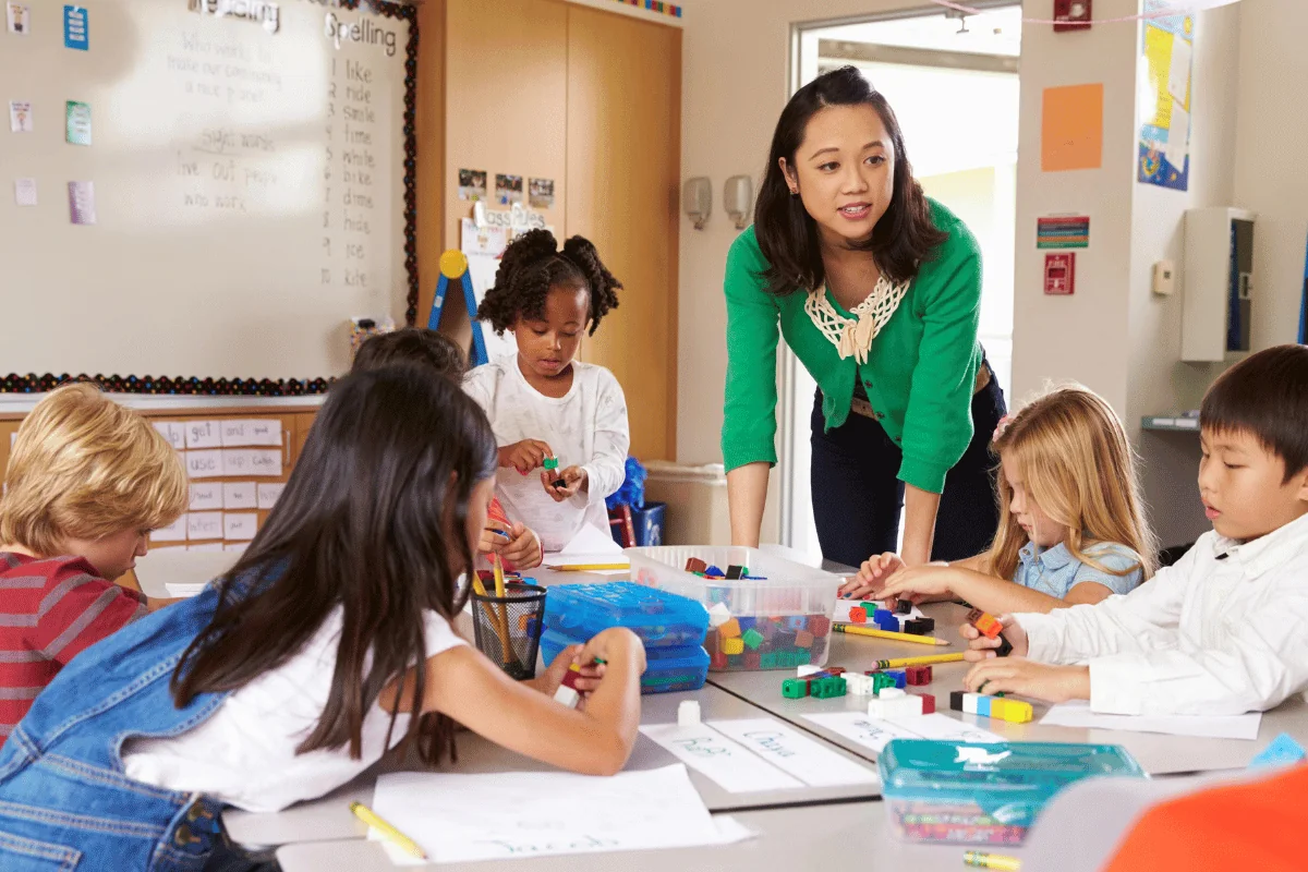 Enseignant stagiaire travaillant en étroite collaboration avec les élèves de maternelle.