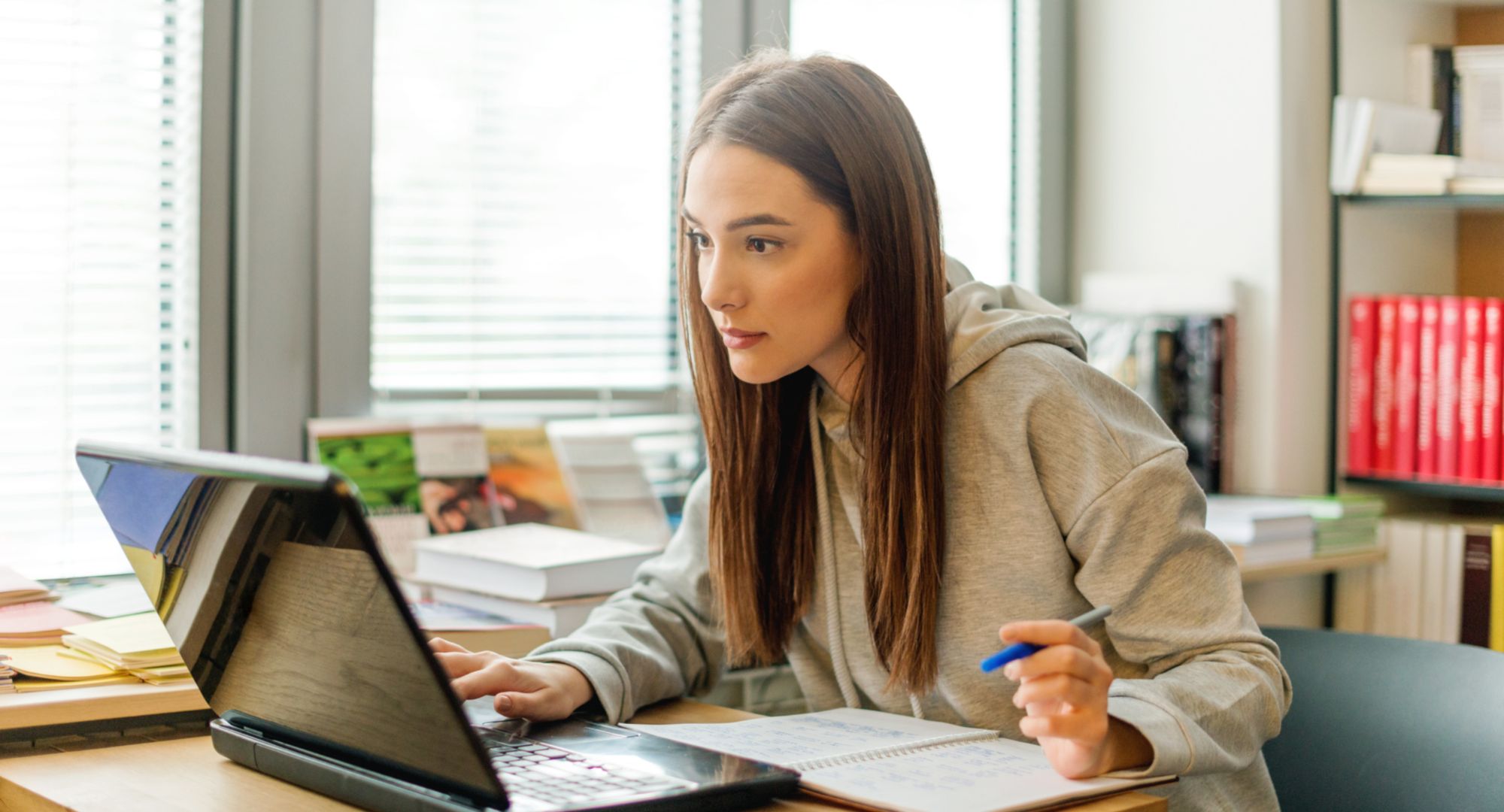 En kvinnlig student som lär sig online samtidigt som hon är hemma.